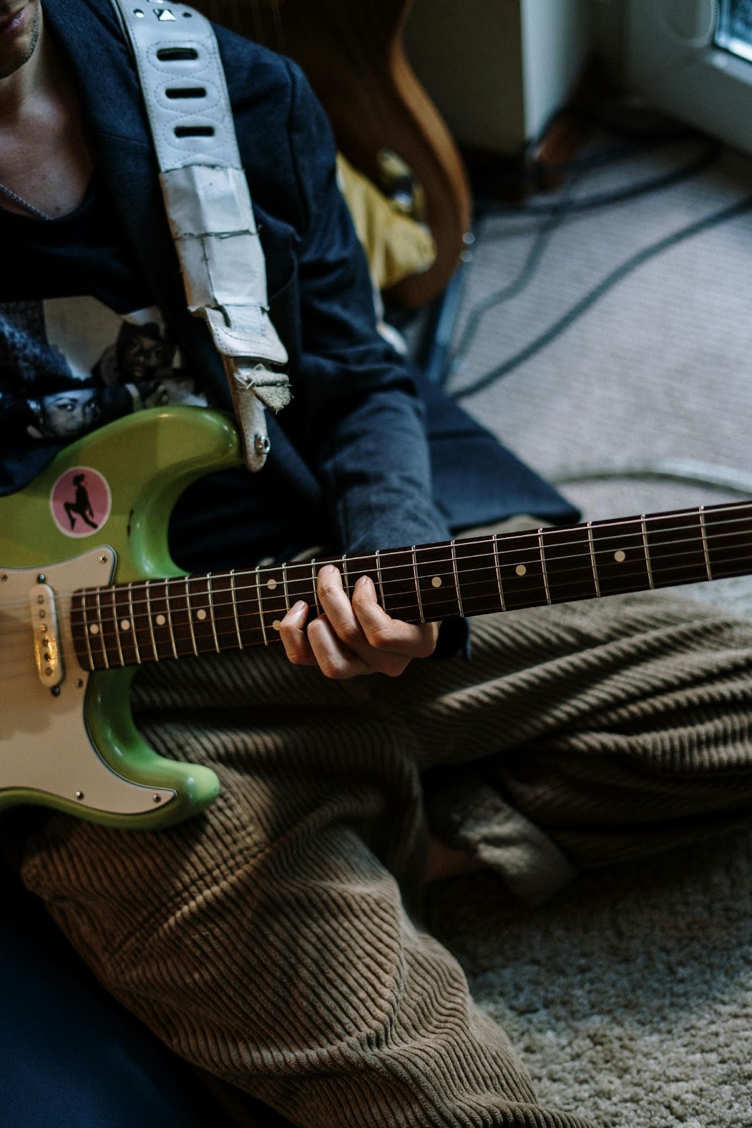 Person Playing Red and White Stratocaster Electric Guitar